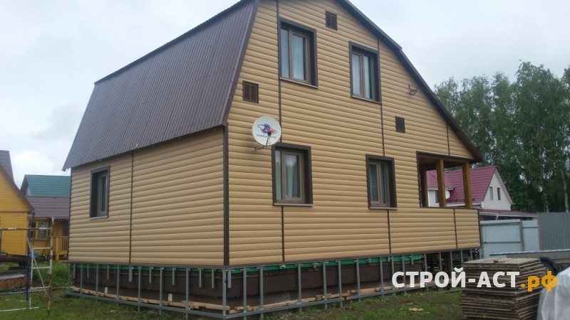 Профессиональная отделка дачи сайдингом Деке цвет Карамель с утеплением с коричневыми углами и обрамлением окон