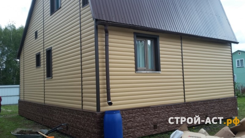 Профессиональная отделка дачи сайдингом Деке цвет Карамель с утеплением с коричневыми углами и обрамлением окон