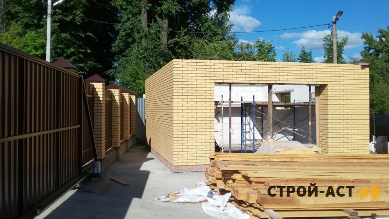 Построить гараж из газосиликатных блоков с облицовкой кирпичом. Фундамент плита, площадка под заезд, забор из кирпичных столбов и профнастила с откатными воротами