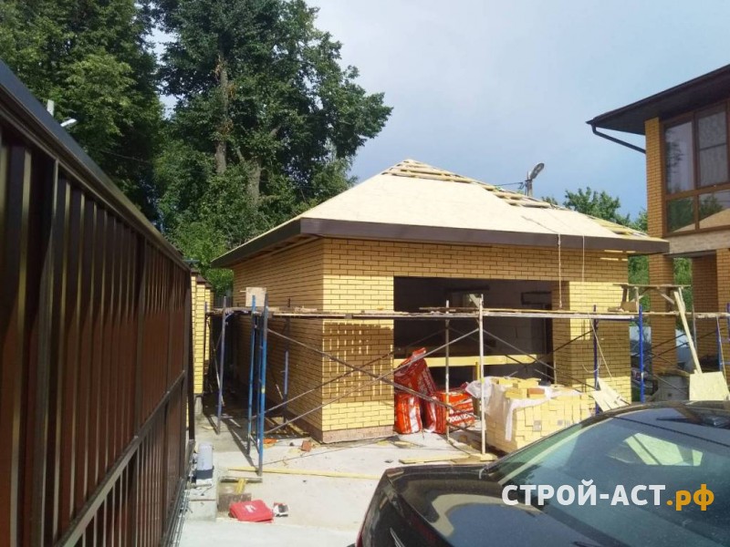 Построить гараж из газосиликатных блоков с облицовкой кирпичом. Фундамент плита, площадка под заезд, забор из кирпичных столбов и профнастила с откатными воротами