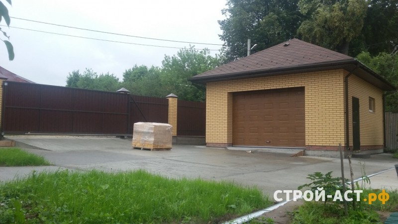Построить гараж из газосиликатных блоков с облицовкой кирпичом. Фундамент плита, площадка под заезд, забор из кирпичных столбов и профнастила с откатными воротами