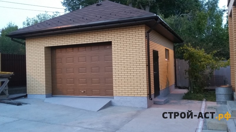 Построить гараж из газосиликатных блоков с облицовкой кирпичом. Фундамент плита, площадка под заезд, забор из кирпичных столбов и профнастила с откатными воротами
