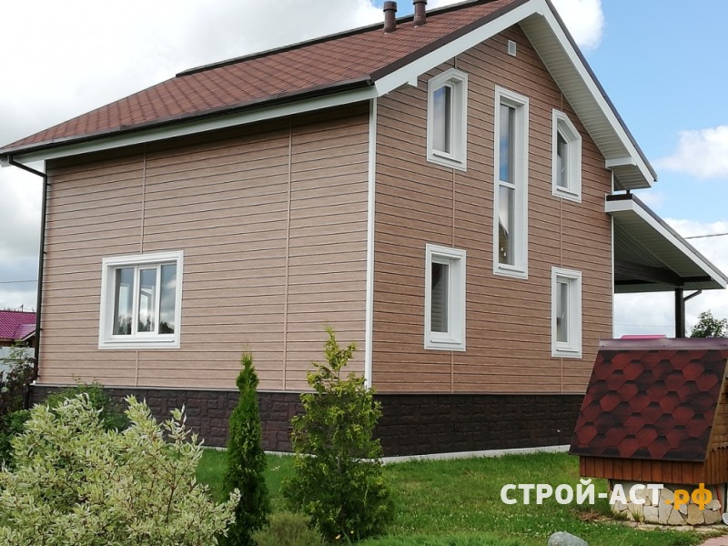 Отделка деревянного дома сайдингом  Деке Люкс цвет Кедр с обрамлением окон Альта Декор цвет Белоснежный